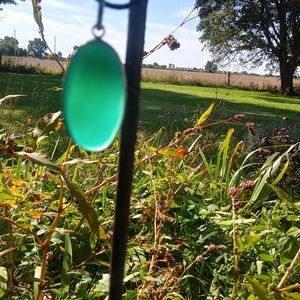 Green crystal pendant on black cord